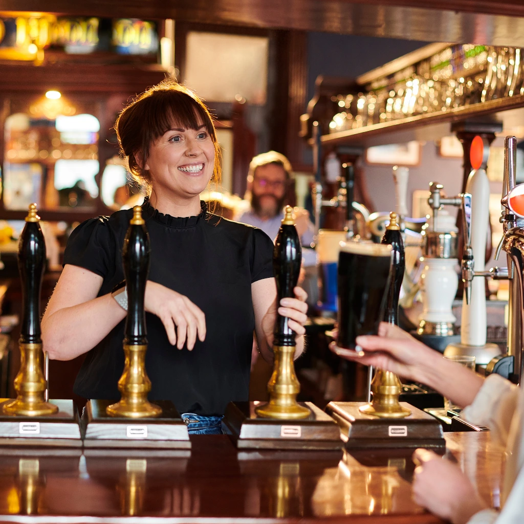 Bartender serving drinks at a pub bar