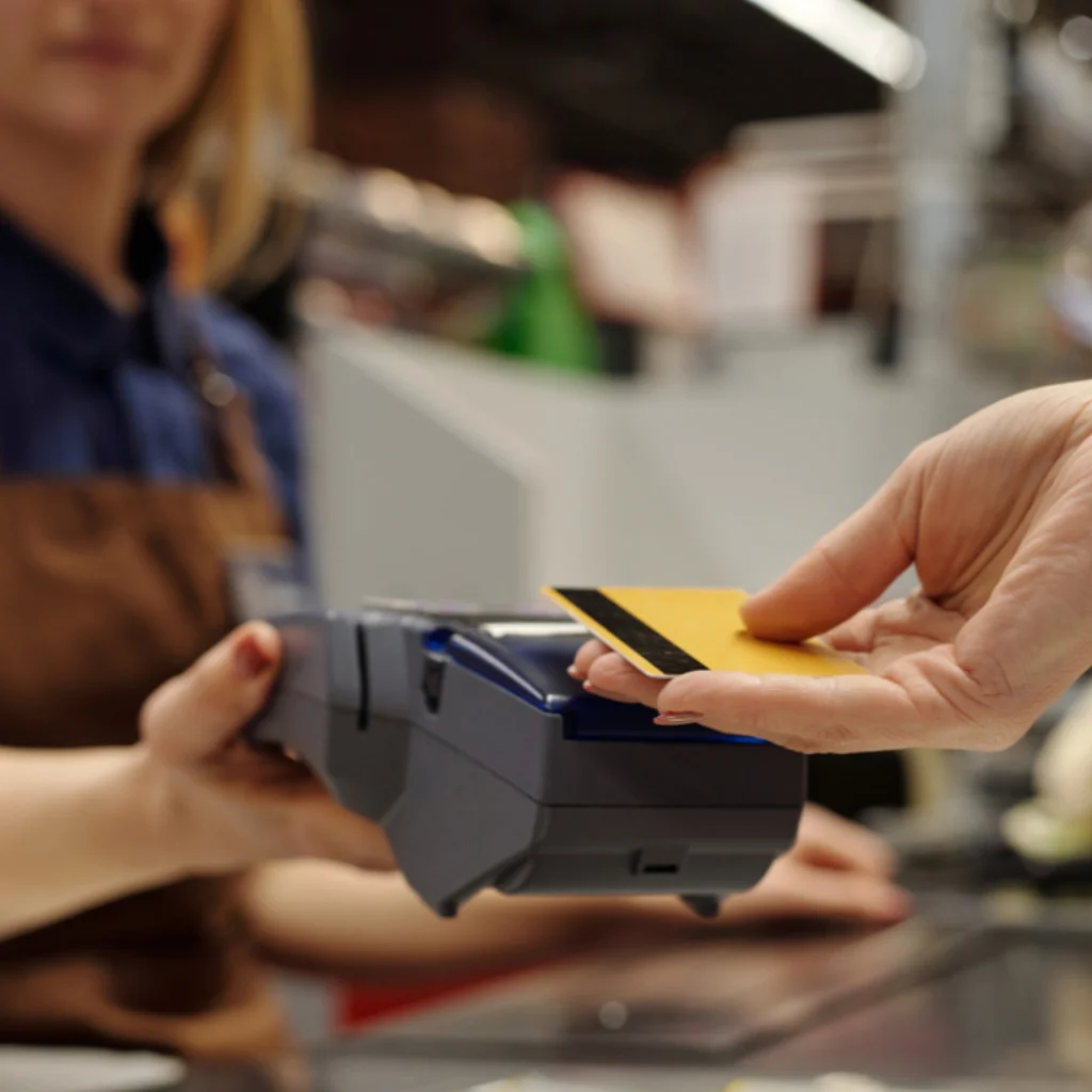 Customer tapping card on EFTPOS terminal at hospitality venue counter