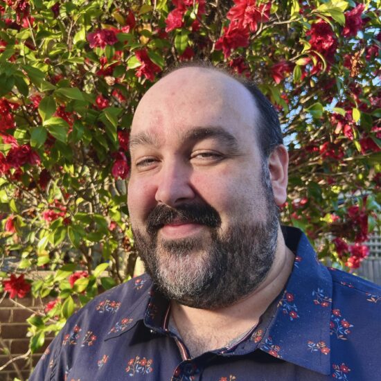 Max Fraser, Service Desk Technician at All IT Services, smiling in front of a colourful mural
